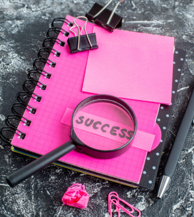 view-pink-notepad-with-pen-magnifier-success-note-gray-background